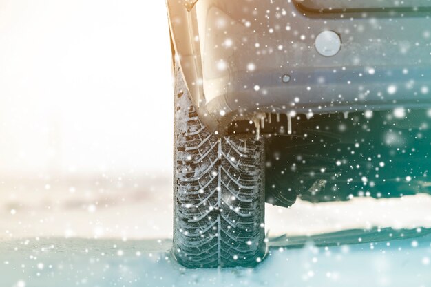 Close-up of car wheels rubber tires in deep winter snow. Transportation and safety concept.