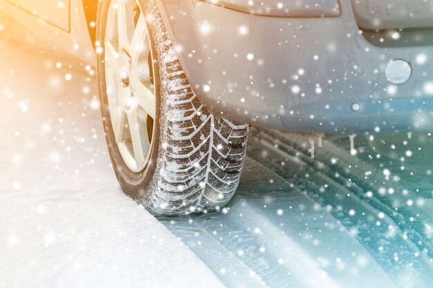 Close-up of car wheels rubber tires in deep winter snow. Transportation and safety concept.