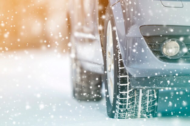 Close-up of car wheels rubber tires in deep winter snow. Transportation and safety concept.