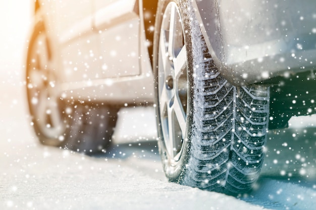 Close-up of car wheels rubber tires in deep winter snow. Transportation and safety concept.