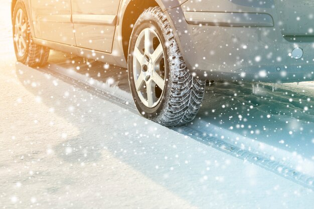 Close-up of car wheels rubber tires in deep winter snow. Transportation and safety concept.