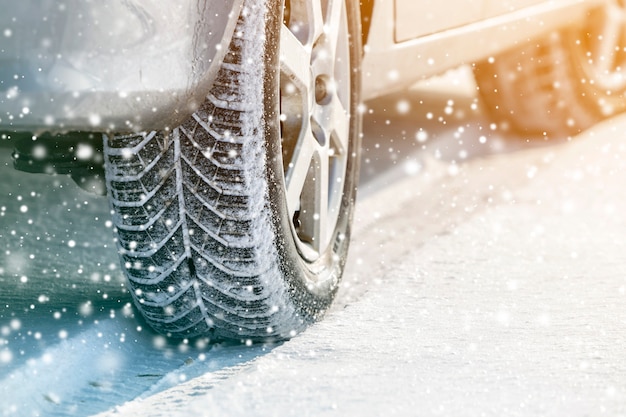 Close-up of car wheels rubber tires in deep winter snow. Transportation and safety concept.