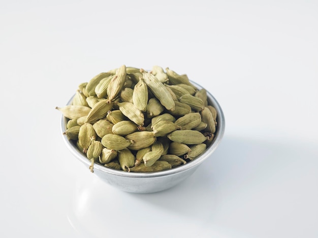 Photo close-up of cardamoms in bowl over white background