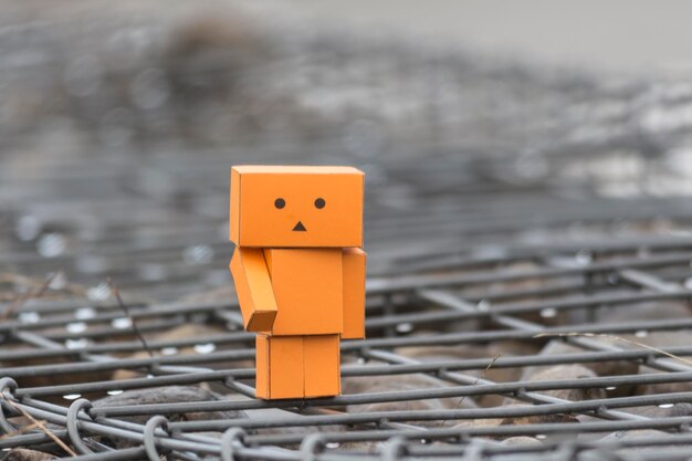 Photo close-up of cardboard toy on metal grate