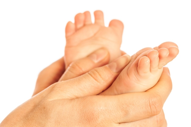 Close-up of caring mother's hands doing massage on the bare legs of a baby after bathing. The concept of care for hygiene and the health of your child