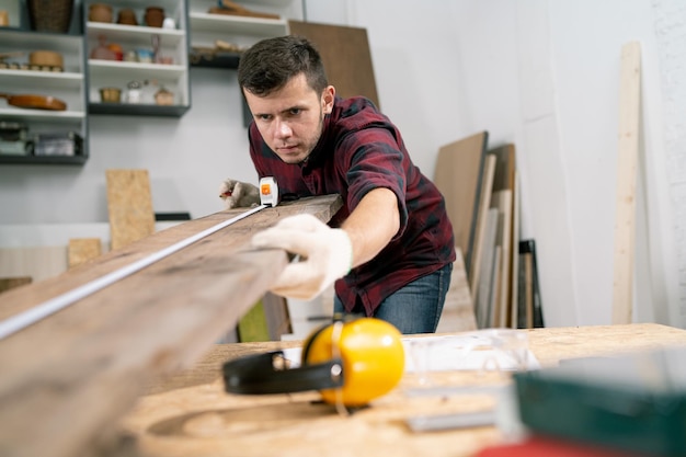 close up of carpenter measuring furniture using a tape measure