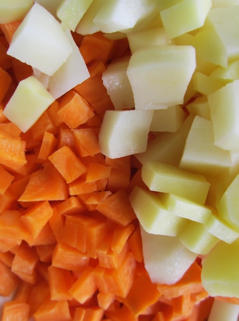 Закройте морковь и картофель. Красочные сырые овощи.