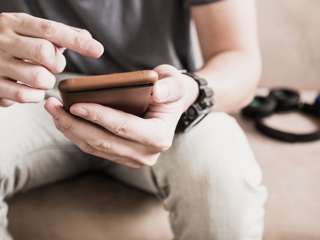 Close up of casual man's hands using smart phone.