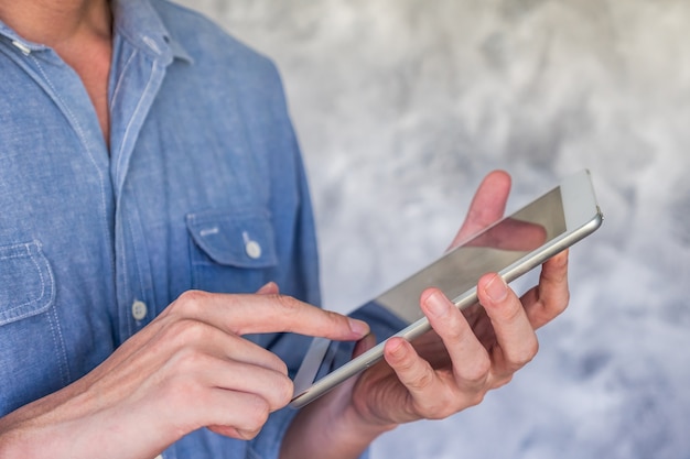 Close up of Casual man using tablet on grunge background