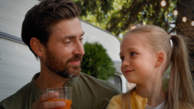 Close up caucasian adult father bearded dad with little daughter child schoolgirl kid drinking fresh