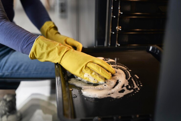 Close up of caucasian woman cleaning oven at home