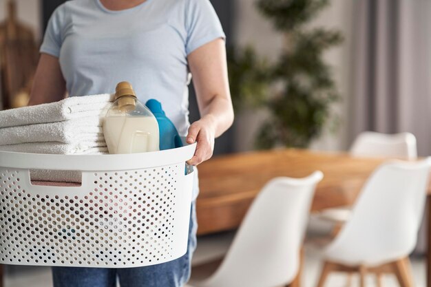 Close up of caucasian woman holding basket with laundry at home