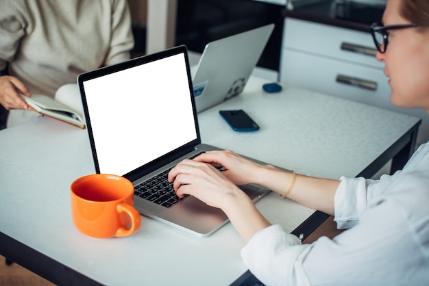 Primo piano delle mani della donna caucasica che digitano sulla tastiera del computer portatile. schermo vuoto, spazio per il testo. sfondo sfocato.