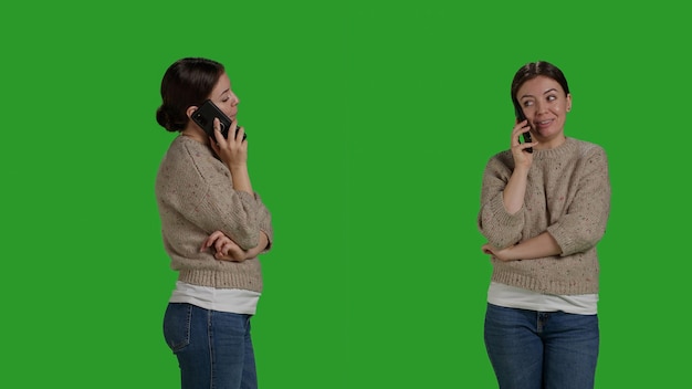 Close up of caucasian woman talking on smartphone line call, using mobile phone line to chat over full body greenscreen. Young cheerful person using telephone to talk to people in studio.