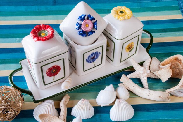 Close-up of ceramic containers with seashells on table