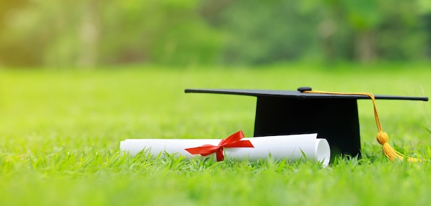 Photo close up certificate paper and education cap on green grass spring time in the outdoor park