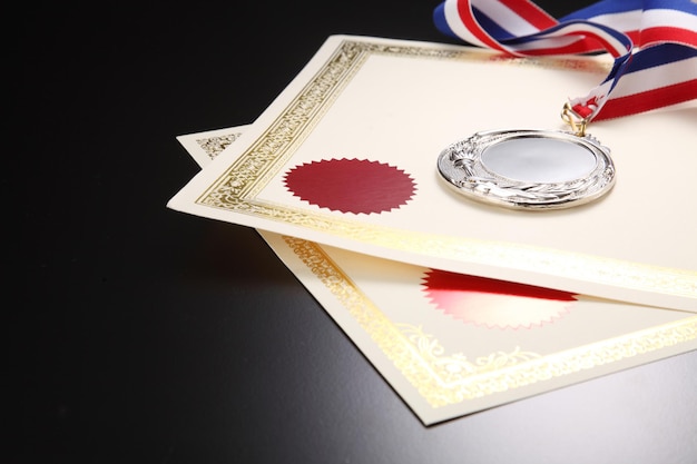 Photo close-up of certificates with medal on table