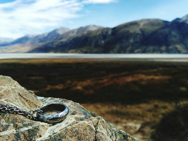 Photo close-up of chain by field on rock