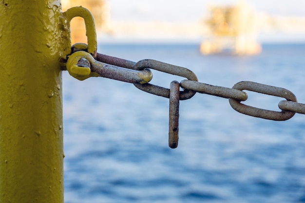 Close-up of chain on railing against sea