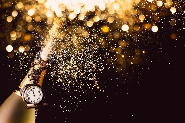 Photo close-up of champagne with pocket watch against black background