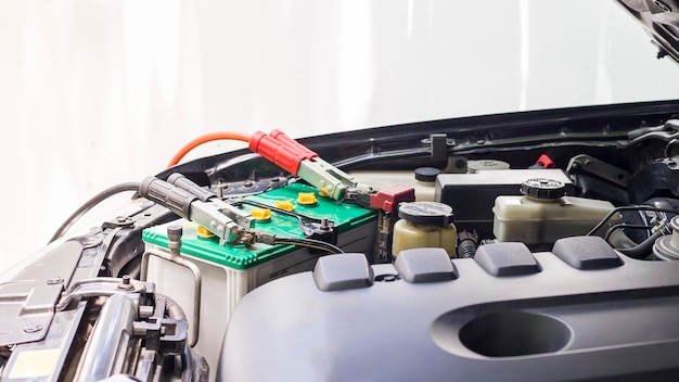 Close up Charging car battery with electricity through jumper cables.