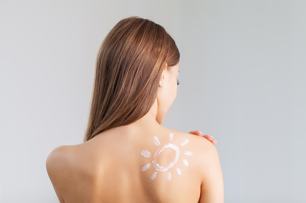 Close up of charming woman with sun protection cream on her shoulder