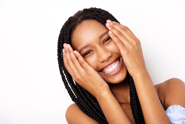 Chiuda sulla giovane donna afroamericana allegra con le mani dal fronte contro fondo bianco