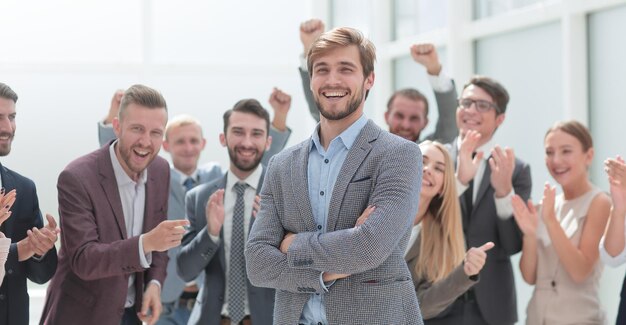 Close up cheerful company employees applauding their colleague