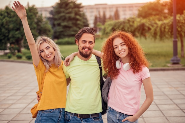 Close up on cheerful friends embracing in park