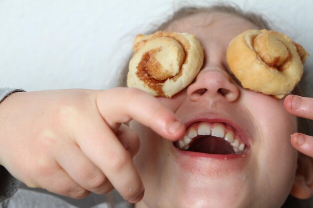 Close-up of cheerful girl with food on eyes