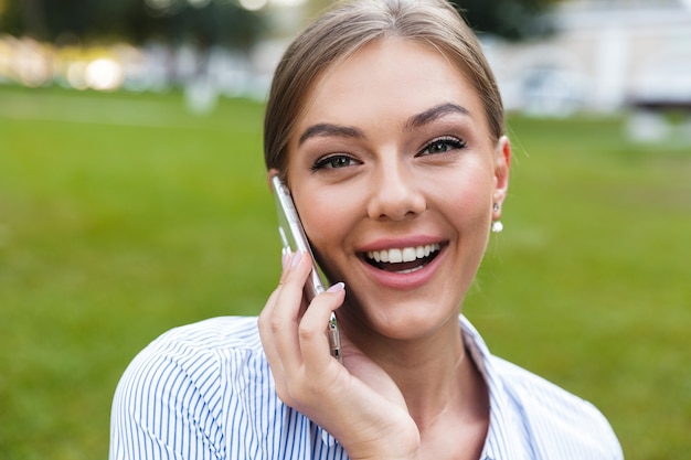 携帯電話で話している陽気な少女のクローズアップ