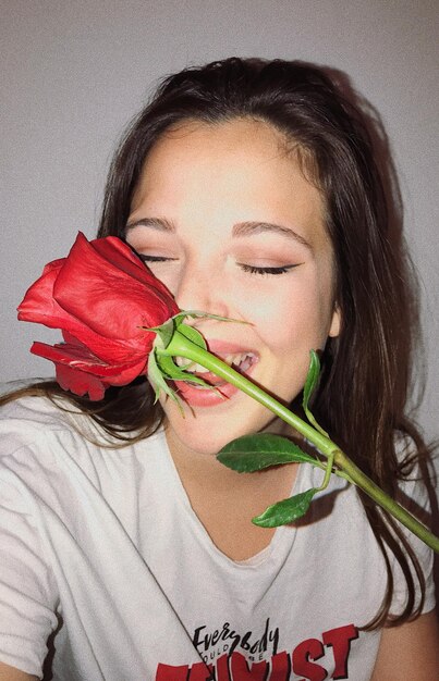 Photo close-up of cheerful young woman with red rose