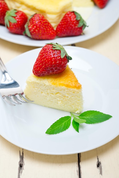 プレートにストロベリーを入れたチーズケーキのスライスをクローズアップ