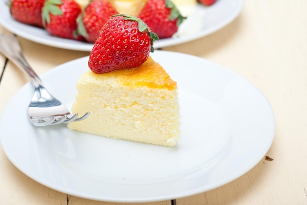 テーブルの上の皿にイチゴのチーズケーキのクローズアップ