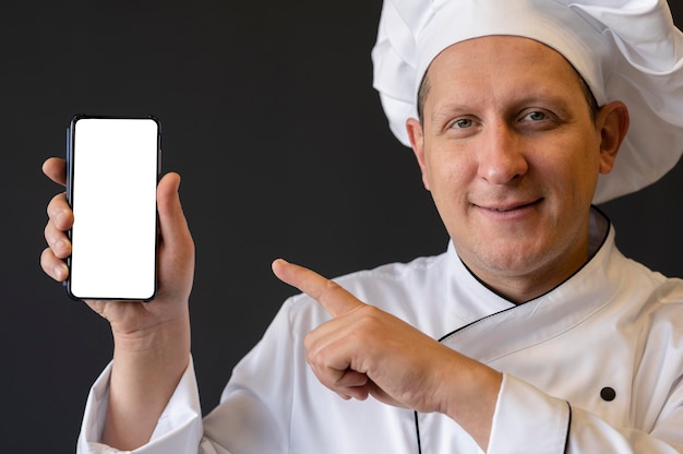 Close-up chef-kok wijzend op smartphone