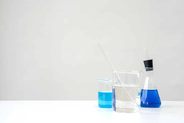 Photo close-up of chemistry glassware on table against white background