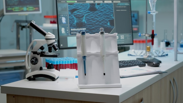 机に誰もいない研究室の化学ピペットのクローズアップ。科学産業で使用される臨床実験場所の職場のテーブルで開発するための医療機器