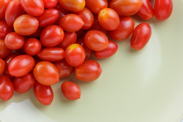 Close up cherry tomato on green ceramic plate .