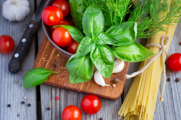 Close up on cherry tomatoes, cucumbers, dill and basil