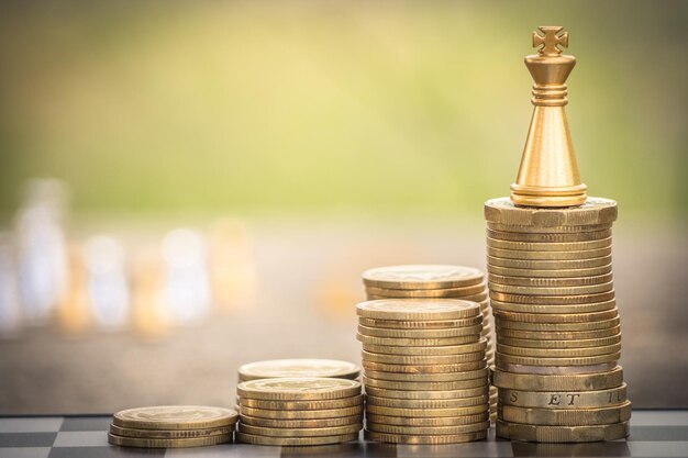 Close-up of chess piece with stacked coins on table