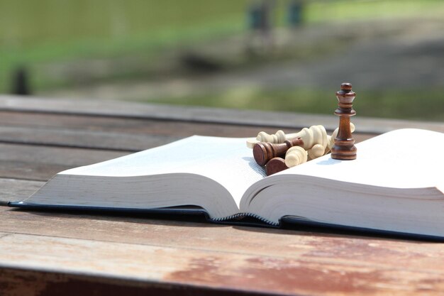 Foto close-up di pezzi di scacchi con un libro sul tavolo