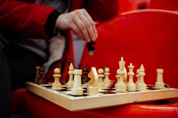 Close up of chess on stadium bleacher Body part of unrecognizable woman playing in board game in cold weather