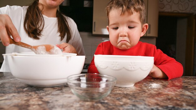 Close up on child bored in the kitchen