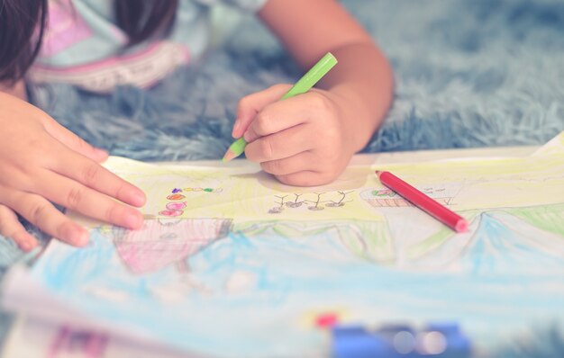 Close up child drawing and painting of her family in home for create greeting card