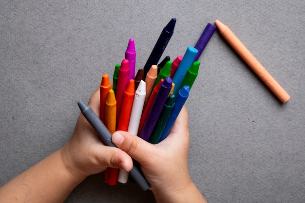 close up child holding crayons