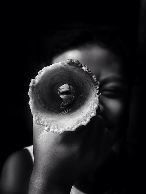 Foto close-up di un bambino che tiene in mano un cono di gelato