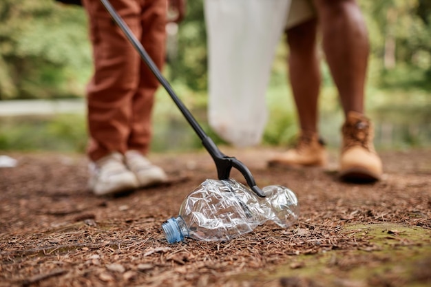 Close up of child picking up plastic bottle outdoors