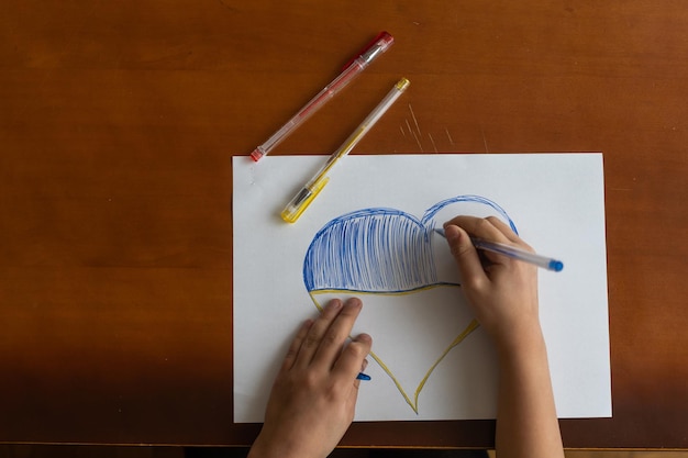 Close-up of childs hands drawing a heart