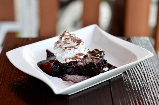 Photo close-up of chocolate cake in plate on table