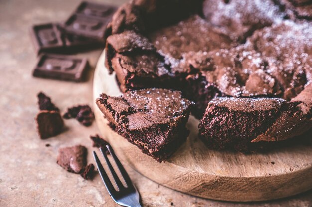 Foto chiuda in su della torta al cioccolato sul vassoio di legno con la forcella